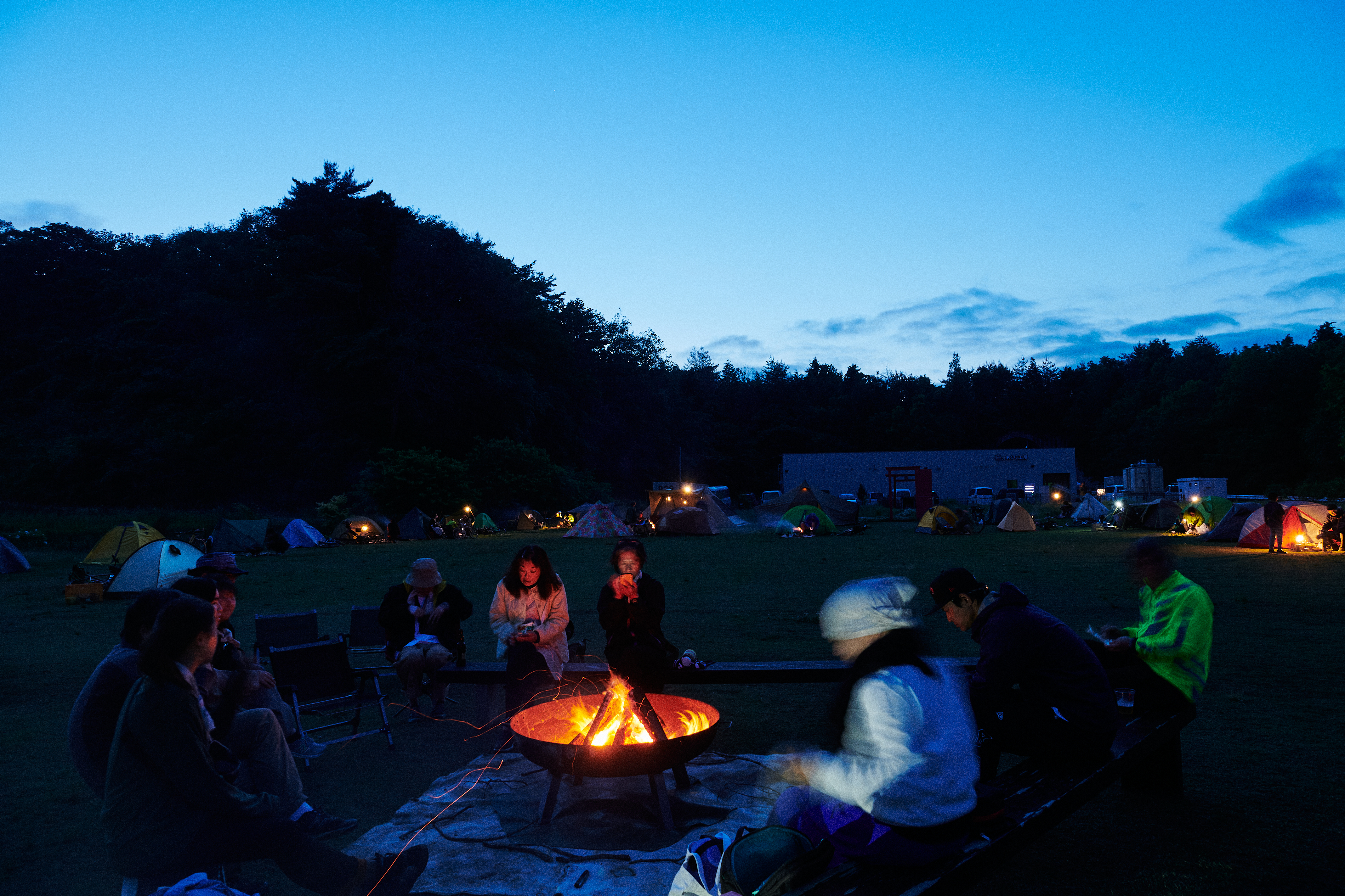 焚き火を囲んで語らうBIKE & CAMPの参加者たち